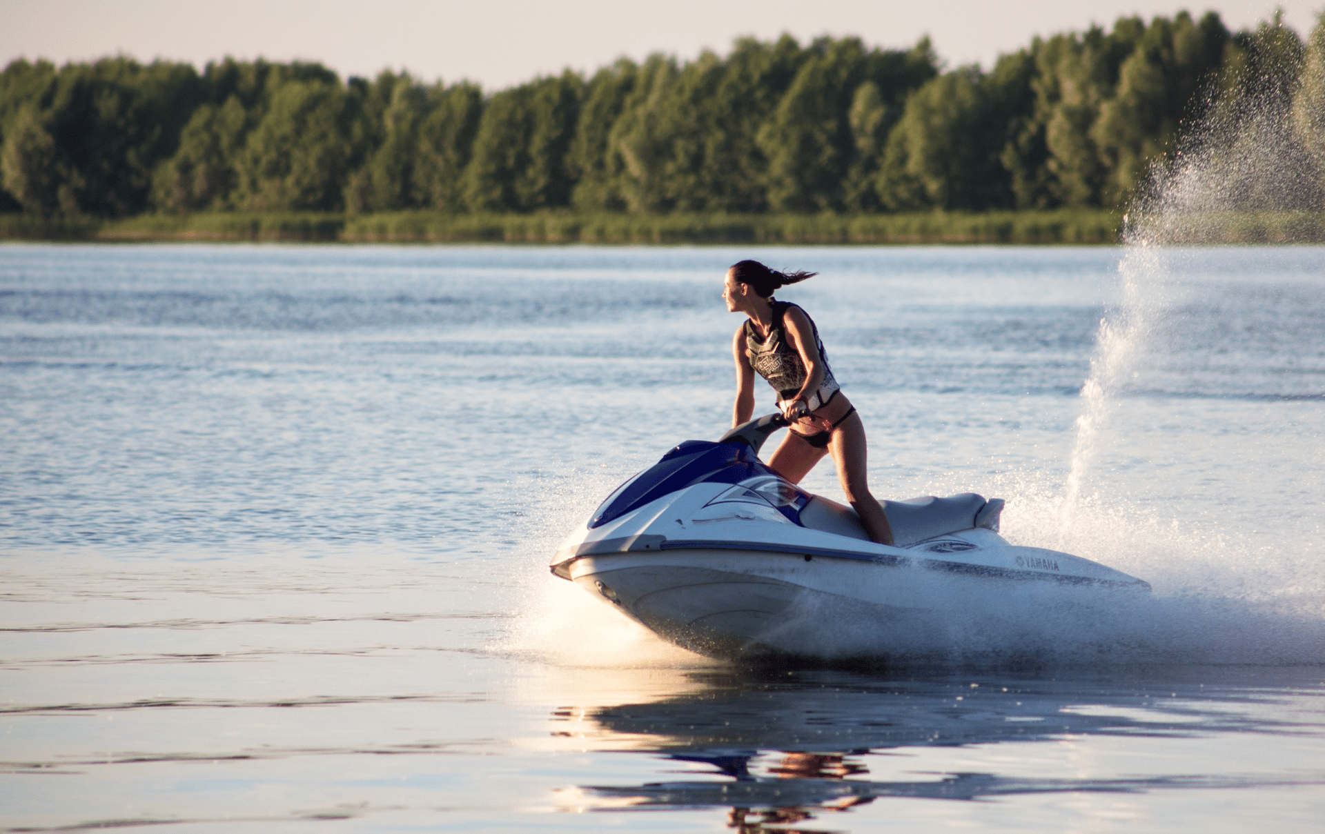 woman riding a jetski on a lake in the sun