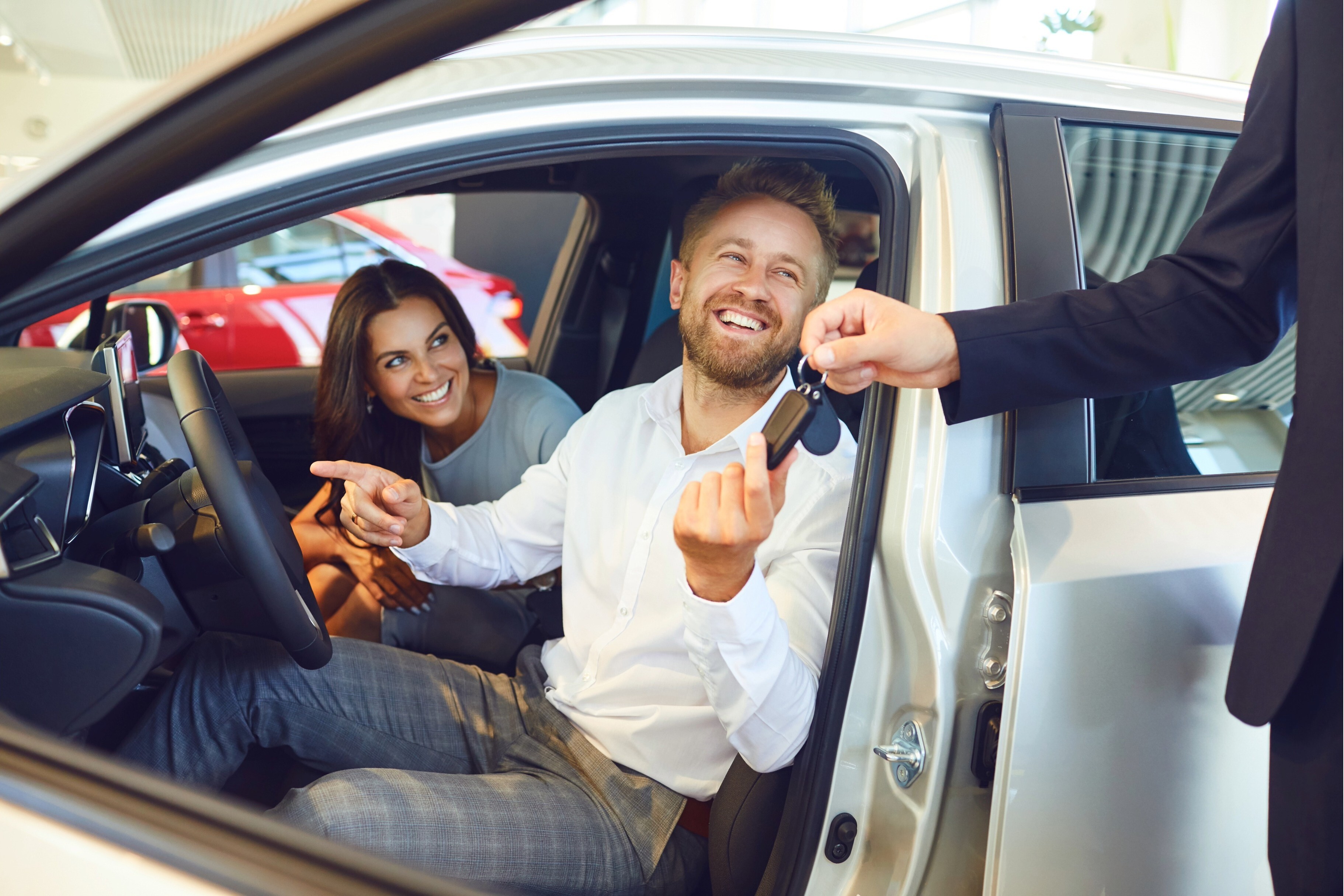 couple in new car accepting keys from dealership