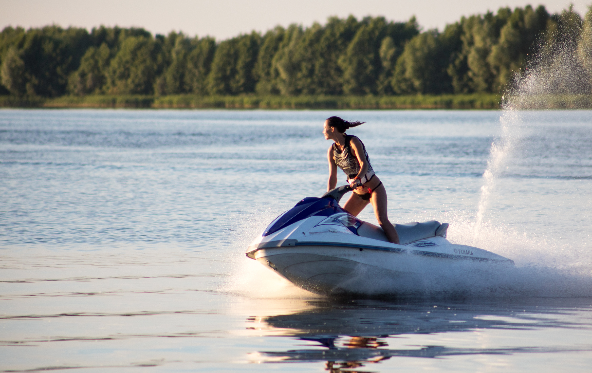 woman riding a jetski on a lake in the sun